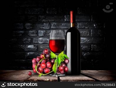 Bottle and glass of red wine and grapes. Bottle red wine and grapes
