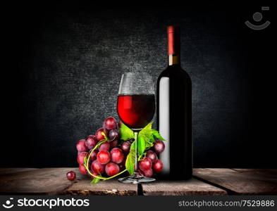 Bottle and glass of red wine and grapes. Glass of red wine