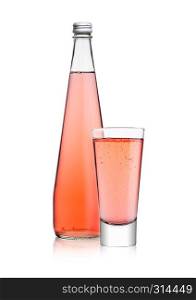 Bottle and glass of sparkling pink soda drink lemonade on white background