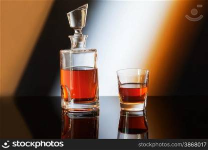 bottle and glass of whiskey on gradient background