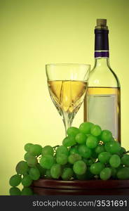 bottle and glass of wine, grape bunch, green background