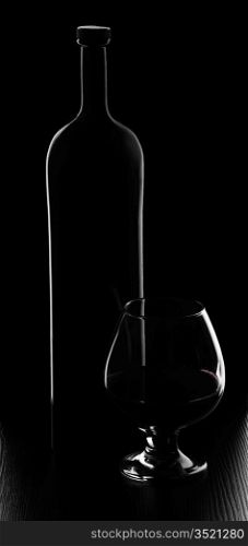 bottle and glass of wine on a black background