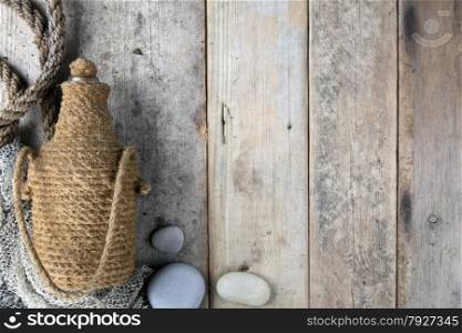 Bottle covered by tar rope with wooden background