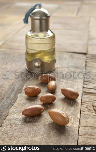 Bottle of argan oil and nuts on the table