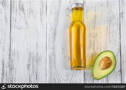 Bottle of avocado oil with fresh avocado: top view