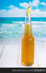 bottle of beer with lime on a beach