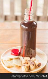 Bottle of black iced coffee with some snack, stock photo