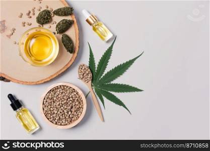 Bottle of CBD oil, THC tincture, cannabis leave, hemp seed on the wooden bowl arranged together on the white background. Hemp plant cannabidiol distillation into liquid for medical use.. Distillation concept of CBD oil feature with hemp seeds on the white background.