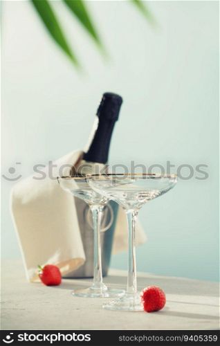 Bottle of ch&agne and glasses on sea and sky background. Summer holiday and romantic party concept. Bottle of ch&agne and glasses on sea and sky background.