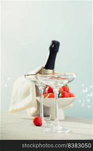 Bottle of ch&agne, two glasses and strawberries on sea and sky background. Summer holiday and romantic party concept