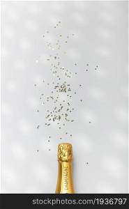 Bottle of champagne and confetti on whitebackground, top view. Flat lay composition for entrepreneurs, bloggers, magazines, websites, social media and instagram