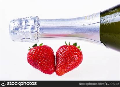 Bottle of champagne and strawberries over white background