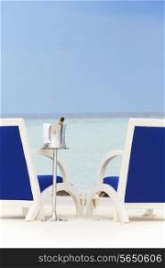 Bottle Of Champagne Between Chairs On Beautiful Beach