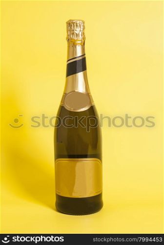 Bottle of champagne on yellow background