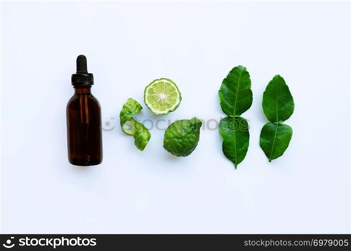 Bottle of essential oil and  fresh bergamot fruit with leaves isolated on white background.