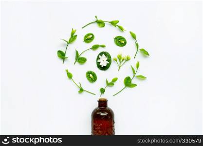 Bottle of essential oil with jasmine flower and leaves on white background