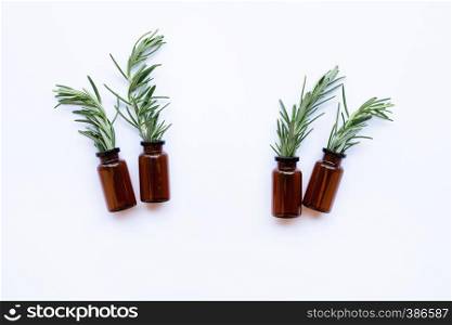 Bottle of essential oil with rosemary on white background. Copy space
