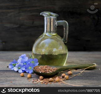 bottle of flax oil with flowers and seeds on rustic wood. bottle of flax oil with flowers and seeds