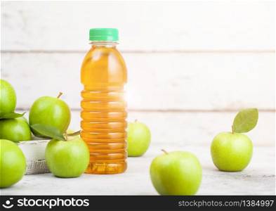 Bottle of fresh organic apple juice with granny smith and british bramley apples in box on wooden background.