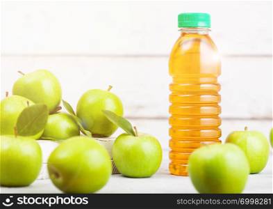 Bottle of fresh organic apple juice with green apples in box on wooden background with sun light Space for text