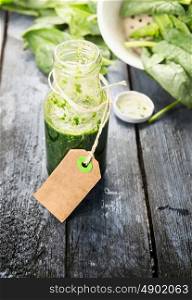 bottle of green spinach smoothie with blank notes sign