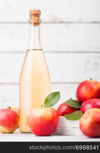 Bottle of homemade organic apple cider with fresh apples in box on wooden background, Glass with ice cubes