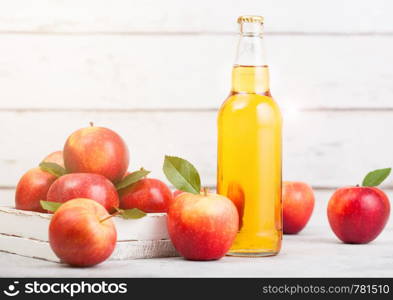 Bottle of homemade organic apple cider with fresh apples in box on wooden background, Glass with ice cubes