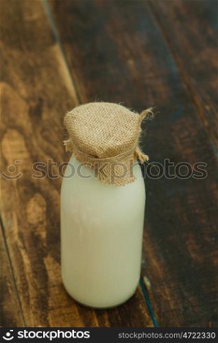 Bottle of milk on a wooden rustic background
