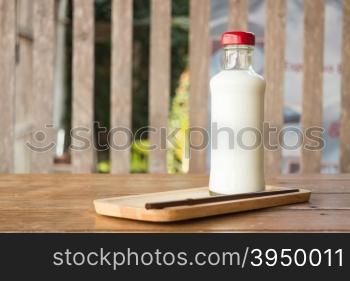 Bottle of milk on wooden table, stock photo