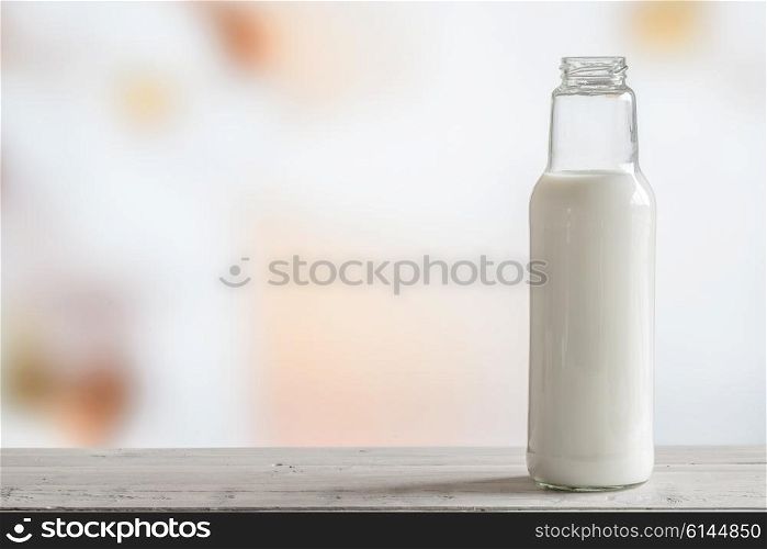 Bottle of milk standing on a wooden table