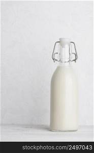 Bottle of milk with swing top closed on white wooden table background