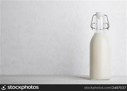 Bottle of milk with vintage swing top lock, closed, on white wooden table with copy space