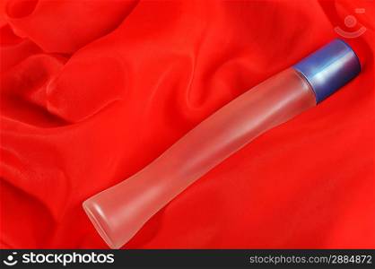Bottle of perfume, isolated on red close up