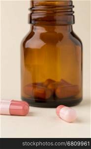 Bottle of pills from the brown glass and colorful capsules