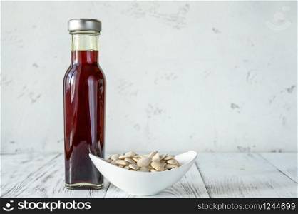 Bottle of pumpkin oil with pumpkin seeds: top view