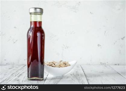 Bottle of pumpkin oil with pumpkin seeds: top view
