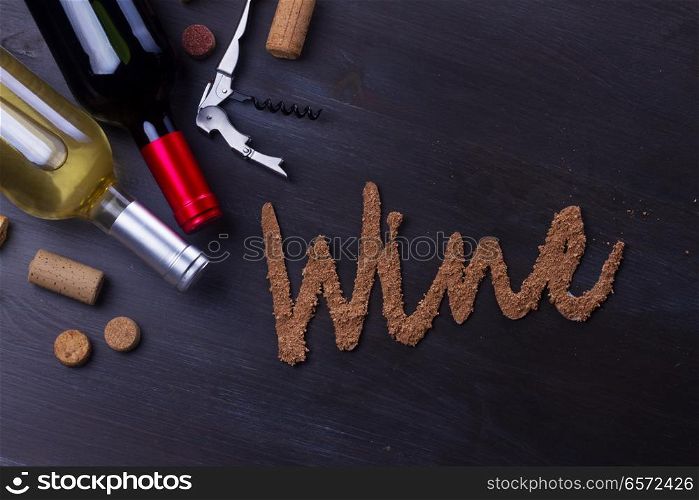 Bottle of red and white wine on table with wine word letters. Glass of red wine