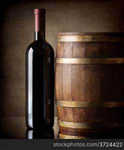 Bottle of red wine and a wooden barrel