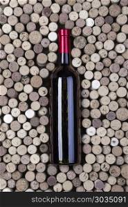 Bottle of red wine and corks on wooden table. Bottle of red wine