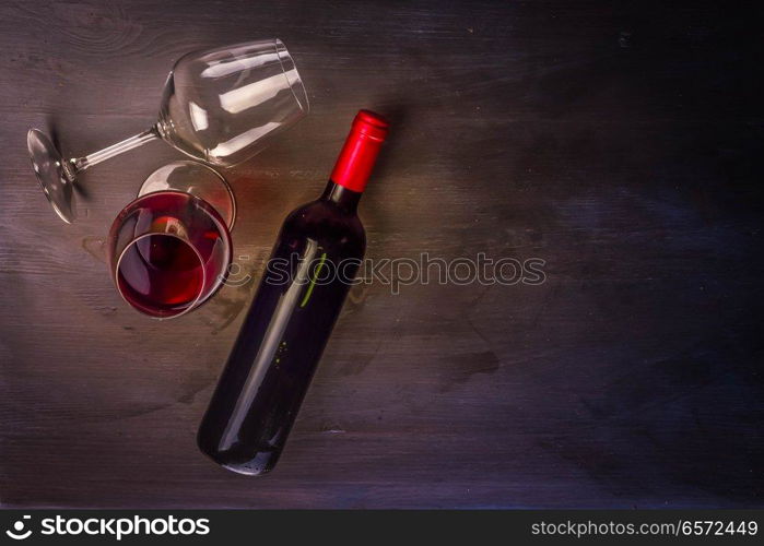 Bottle of red wine and one wine glasses on table with copy space. Glass of red wine