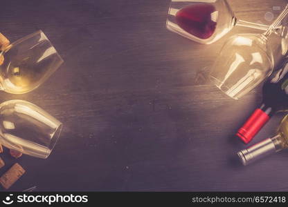 Bottle of red wine and two wine glasses on dark, flat lay frame with copy space, toned image. Glass of red wine