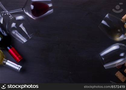 Bottle of red wine and two wine glasses on dark, flat lay frame with copy space. Glass of red wine