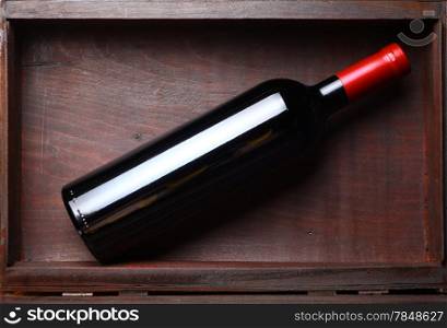 Bottle of red wine in an old wooden box