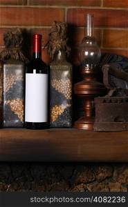 Bottle of red wine with a blank label template standing on a fireplace shelf with various vintage objects