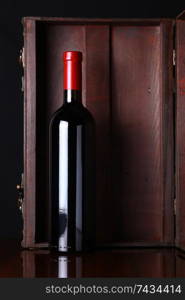 Bottle of red wine with a wooden box in the background