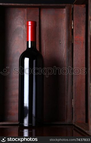 Bottle of red wine with a wooden box in the background