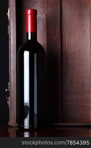 Bottle of red wine with a wooden box in the background