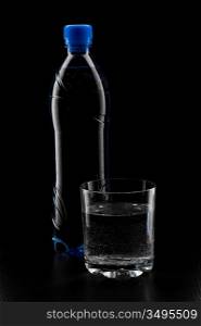 bottle of soda water and a glass isolated on a black background