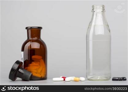 Bottle of water, a glass medicine bottle and different pills
