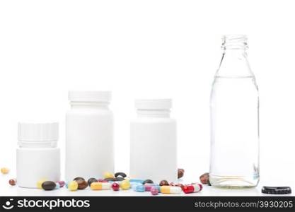 Bottle of water, pill bottle and colorful pills on white background